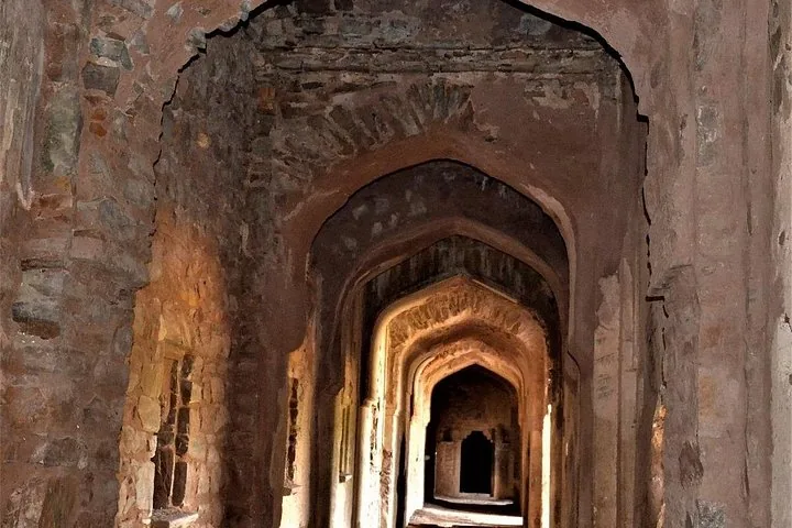 Vista interior de los arcos de piedra y pasillos dentro de una histórica estructura en ruinas